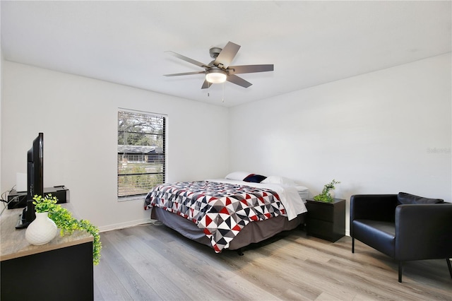 bedroom featuring a ceiling fan, light wood-style flooring, and baseboards