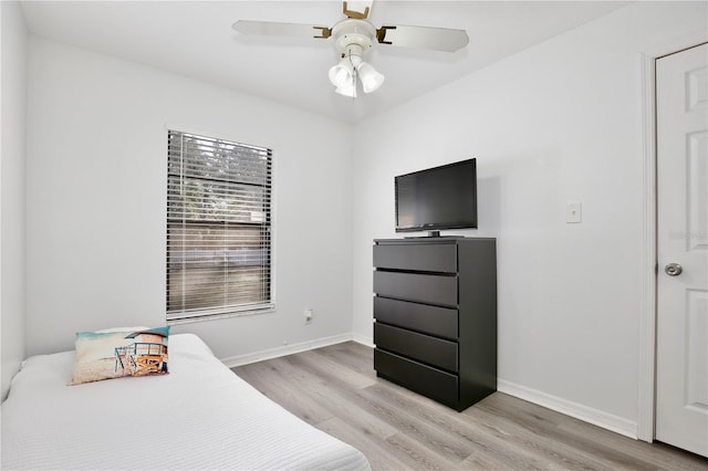 bedroom featuring light wood-type flooring, a ceiling fan, and baseboards