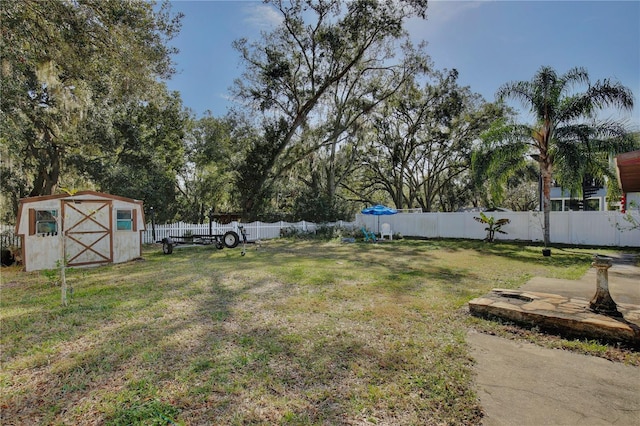 view of yard featuring an outbuilding, a storage shed, and a fenced backyard