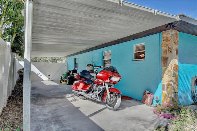 exterior space with an attached carport, fence, and a gate