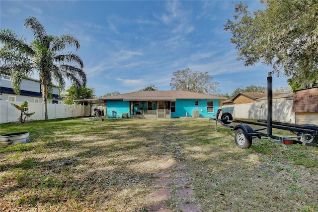 back of property featuring a fenced backyard and a yard