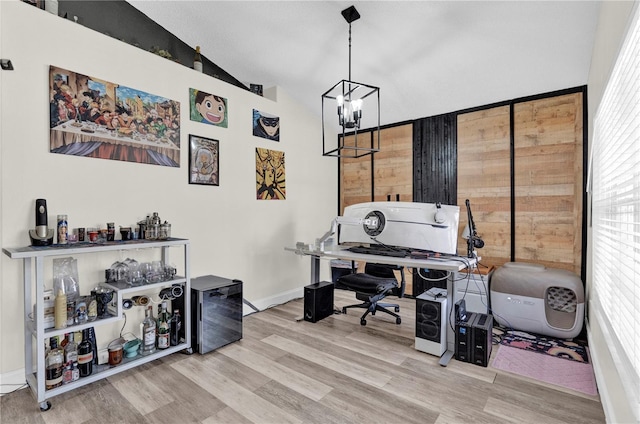 office featuring lofted ceiling, hardwood / wood-style floors, and a chandelier