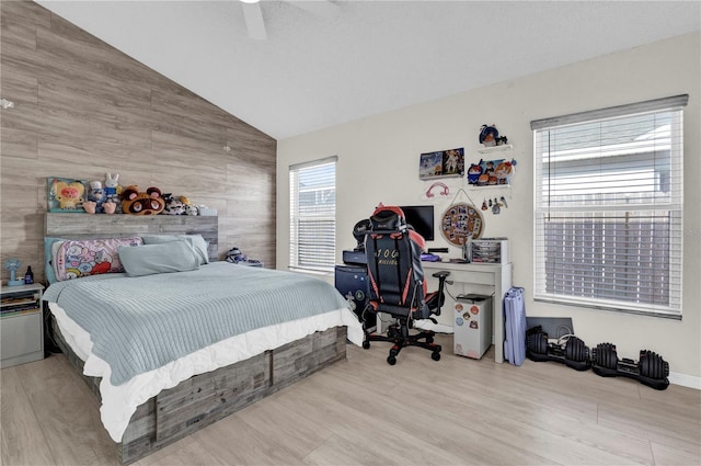 bedroom featuring ceiling fan, lofted ceiling, and light hardwood / wood-style flooring