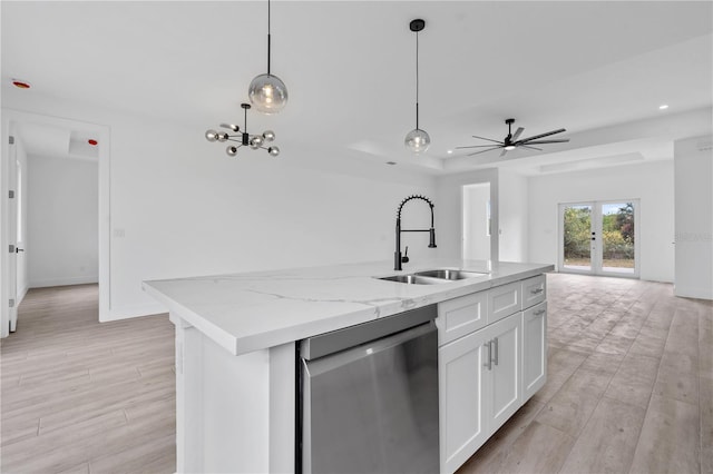 kitchen featuring sink, hanging light fixtures, stainless steel dishwasher, a kitchen island with sink, and white cabinets