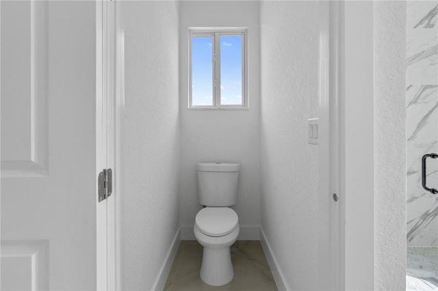 bathroom featuring toilet and an enclosed shower