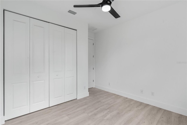 unfurnished bedroom with ceiling fan, light wood-type flooring, and a closet