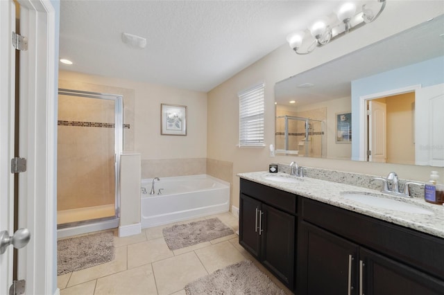 bathroom with vanity, shower with separate bathtub, tile patterned flooring, and a textured ceiling