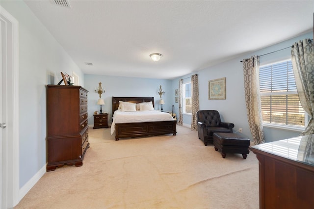 bedroom with multiple windows and light carpet