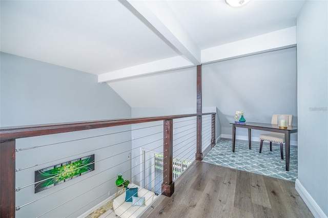 hall featuring hardwood / wood-style flooring and vaulted ceiling with beams