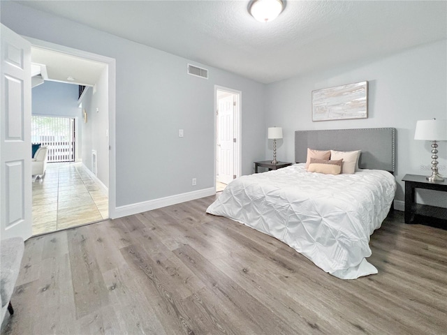 bedroom with hardwood / wood-style flooring and a textured ceiling