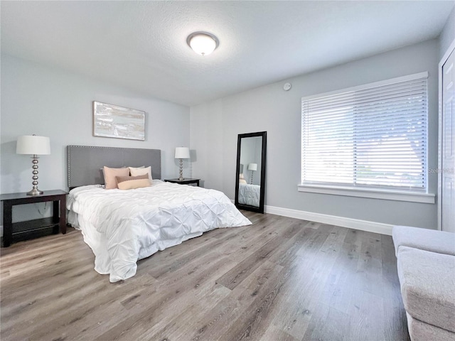 bedroom featuring light hardwood / wood-style flooring and a textured ceiling