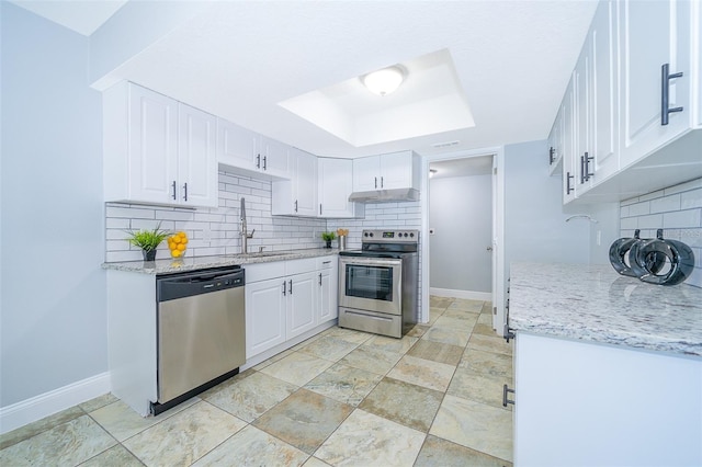 kitchen featuring sink, light stone counters, white cabinets, stainless steel appliances, and backsplash