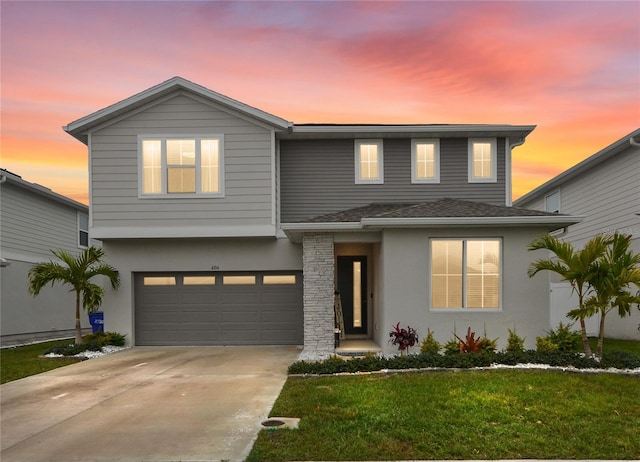 view of front of property with a garage and a lawn