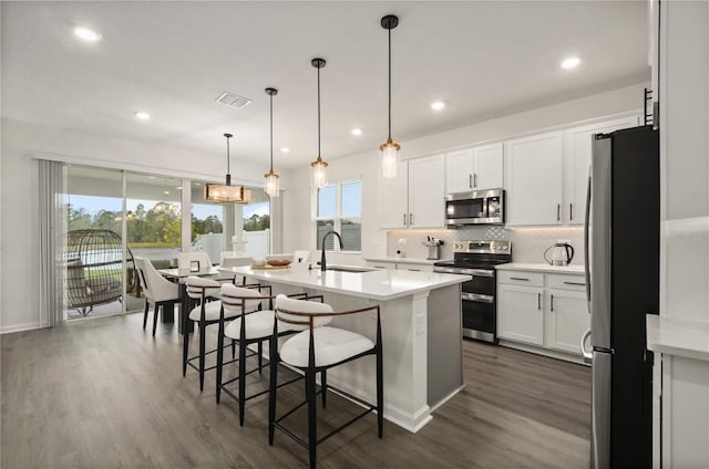 kitchen with white cabinetry, sink, decorative light fixtures, and stainless steel appliances