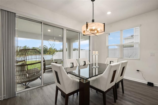 dining space with a water view and dark wood-type flooring