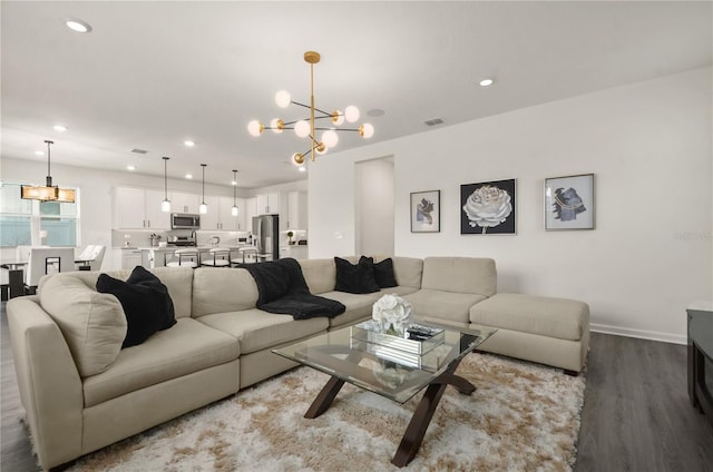 living room featuring an inviting chandelier and hardwood / wood-style floors