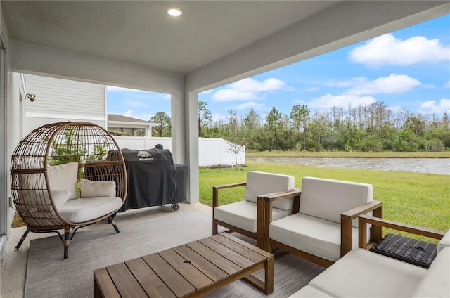 wooden terrace featuring an outdoor living space, a water view, and a lawn