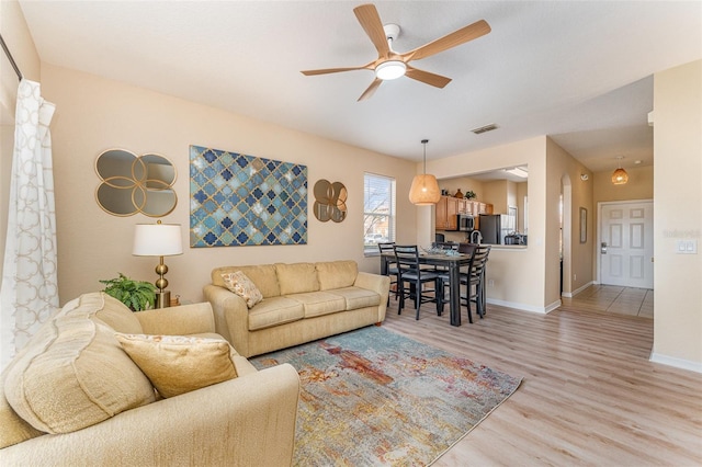 living room featuring ceiling fan and light hardwood / wood-style floors