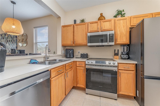 kitchen with pendant lighting, stainless steel appliances, light tile patterned flooring, and sink