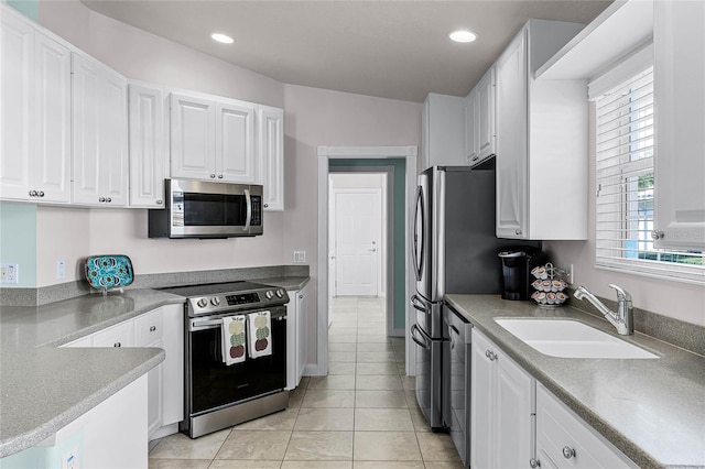 kitchen featuring white cabinetry, sink, light tile patterned floors, and appliances with stainless steel finishes