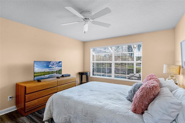 bedroom featuring ceiling fan, dark wood-type flooring, and a textured ceiling