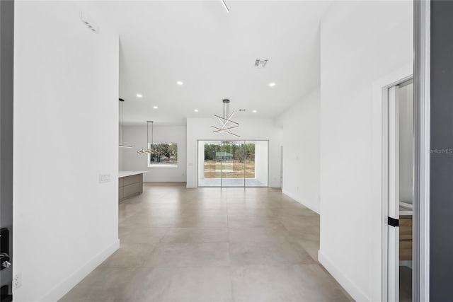 unfurnished living room with a notable chandelier