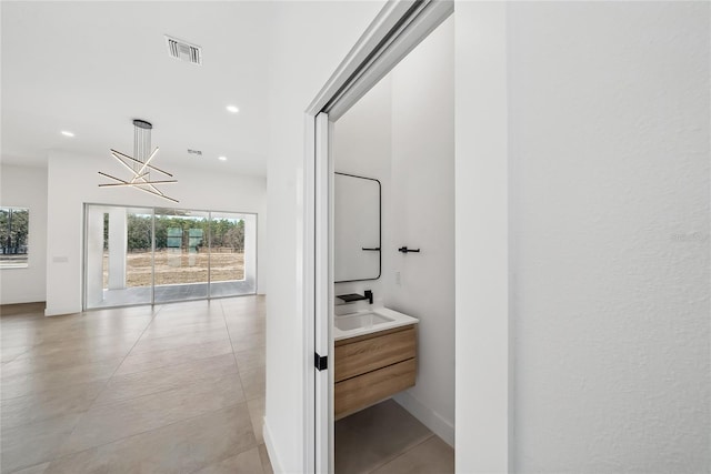 bathroom with tile patterned flooring, vanity, and a chandelier