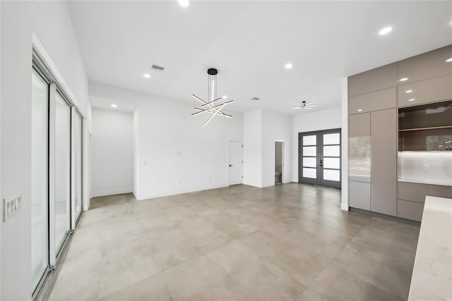 interior space with a notable chandelier and french doors