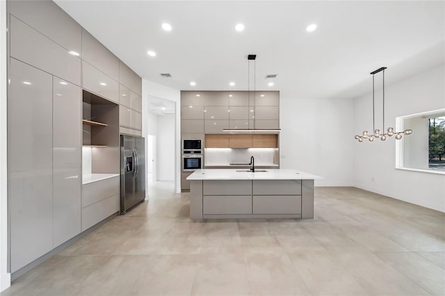 kitchen with appliances with stainless steel finishes, gray cabinetry, and decorative light fixtures