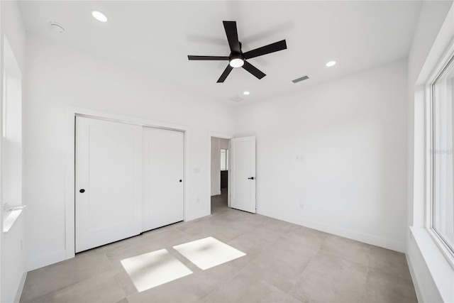 unfurnished bedroom with ceiling fan and a closet