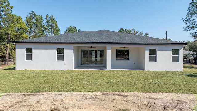 rear view of house with ceiling fan, a patio, and a lawn