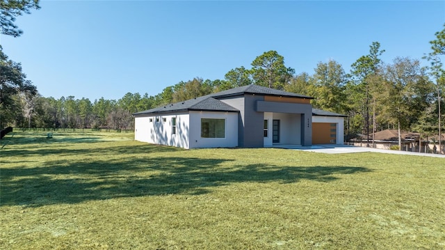 rear view of house with a garage and a yard