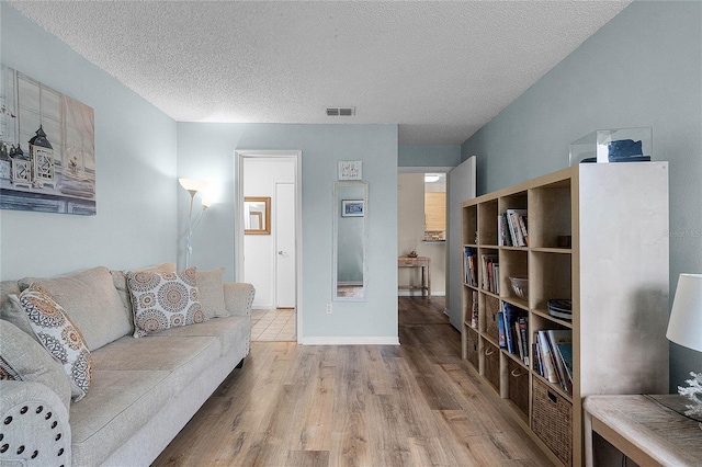 living room featuring a textured ceiling and light wood-type flooring