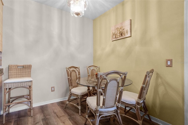 dining area featuring hardwood / wood-style flooring and a notable chandelier