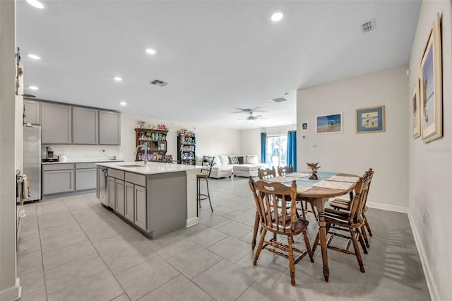 dining room featuring sink, light tile patterned floors, and ceiling fan