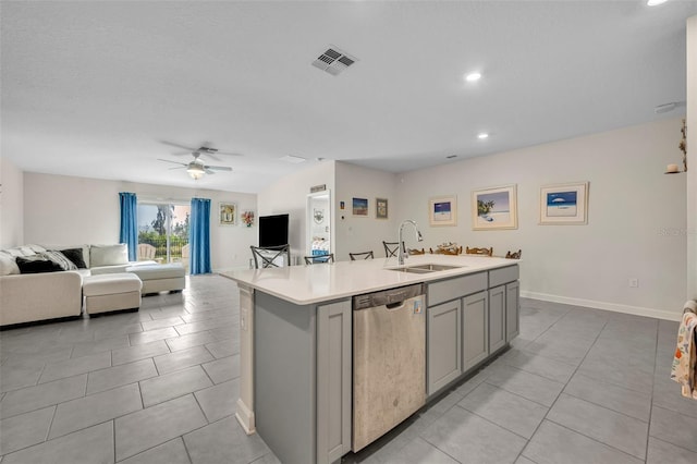 kitchen with dishwasher, sink, gray cabinetry, ceiling fan, and a center island with sink