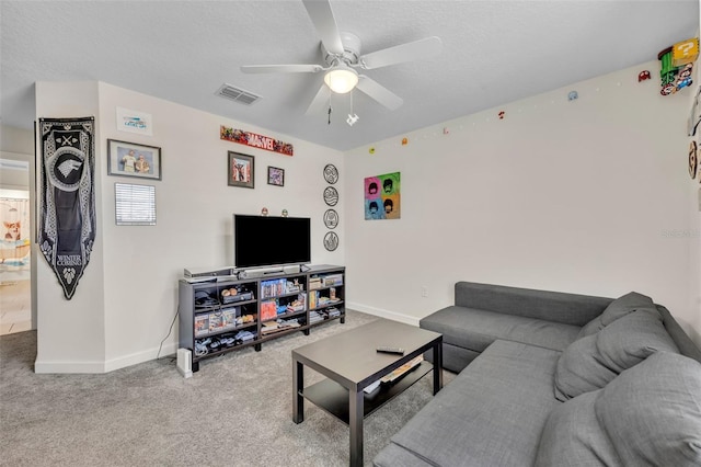 carpeted living room featuring ceiling fan and a textured ceiling