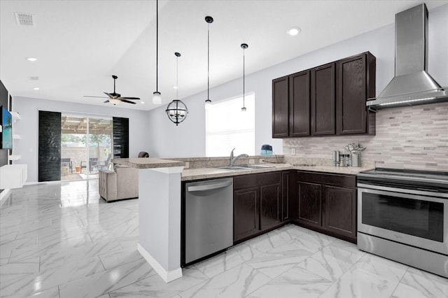 3337 Reedy Glen Dr, Kissimmee, FL 34758 - kitchen with wall chimney range hood, sink, hanging light fixtures, stainless steel appliances, and tasteful backsplash