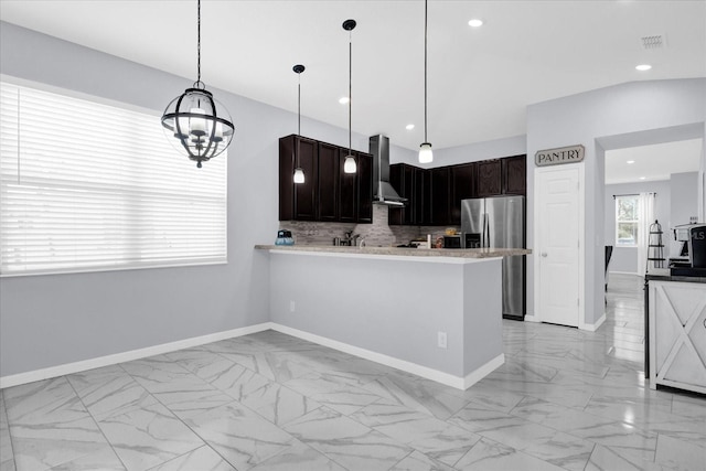 3337 Reedy Glen Dr, Kissimmee, FL 34758 - kitchen with hanging light fixtures, stainless steel fridge with ice dispenser, decorative backsplash, kitchen peninsula, and wall chimney exhaust hood