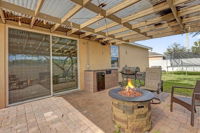 3337 Reedy Glen Dr, Kissimmee, FL 34758 - view of patio / terrace with a trampoline, a grill, a fire pit, and an outdoor kitchen