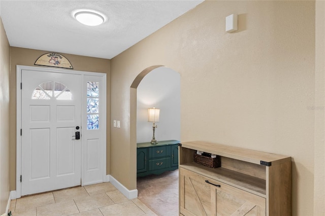 foyer with light tile patterned floors and a textured ceiling