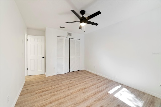 unfurnished bedroom featuring light hardwood / wood-style floors, a closet, and ceiling fan