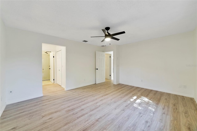 empty room with ceiling fan, a textured ceiling, and light wood-type flooring