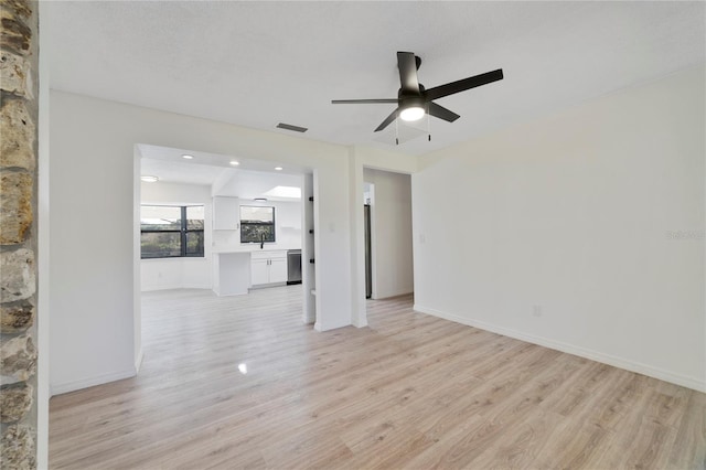 unfurnished living room with ceiling fan, a textured ceiling, and light hardwood / wood-style floors