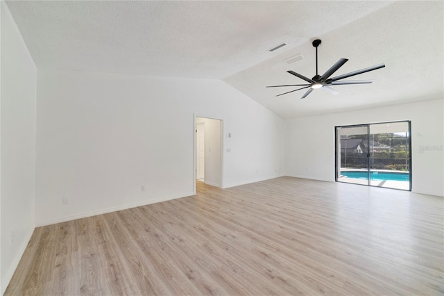 spare room with ceiling fan, light hardwood / wood-style flooring, a textured ceiling, and vaulted ceiling