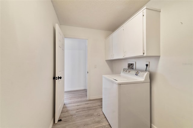 laundry room with cabinets, washer / clothes dryer, light hardwood / wood-style floors, and a textured ceiling