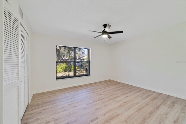 unfurnished bedroom featuring light hardwood / wood-style floors, a closet, and ceiling fan