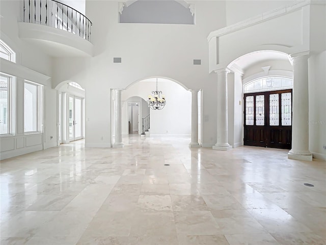 entryway featuring ornate columns, a chandelier, and french doors