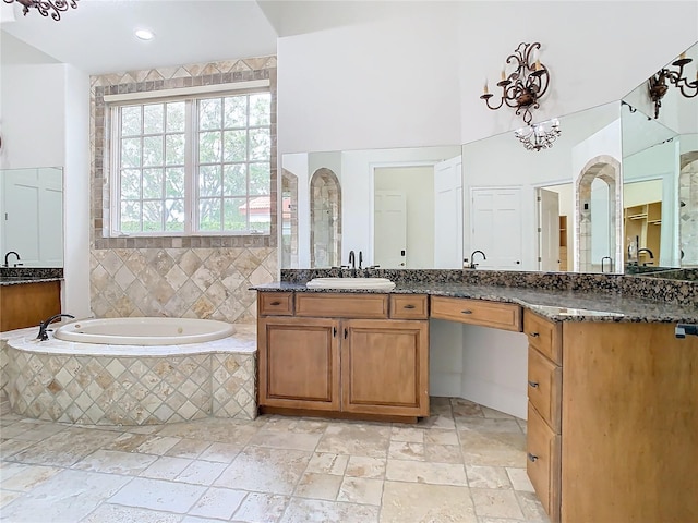 bathroom with vanity and tiled bath