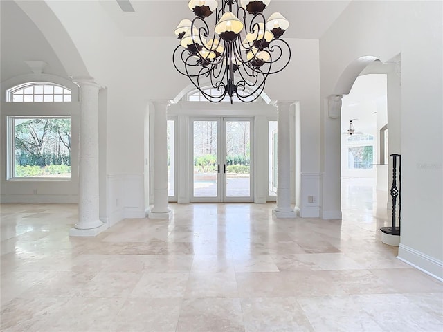 foyer featuring ornate columns and french doors